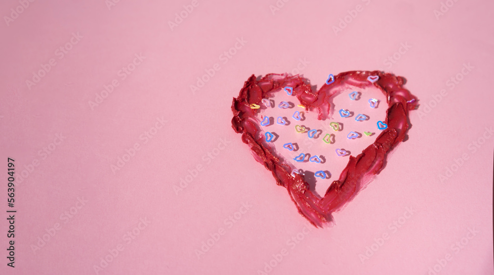 Heart drawn with red lipstick on a pink background. Valentine's day concept.