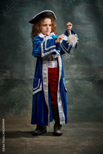 Cinematic portair of beautiful little girl dressed up as medieval knight, little prince over dark vintage style background, Fashion, beauty, emotions, theater concept