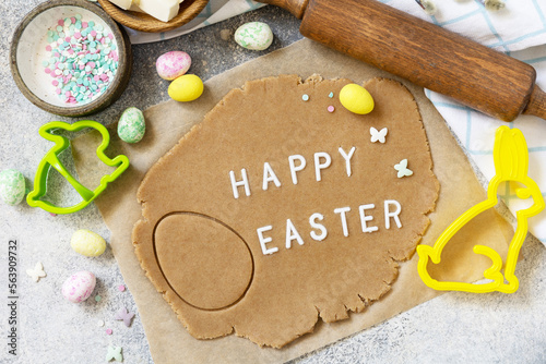 Background for baking or cooking Easter cookies. Ingredients and kitchen utensils for baking on a light stone table. View from above.