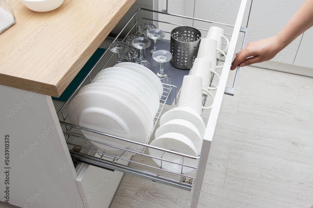 Pullout shelf with dishes in a modular kitchen. Modern kitchen