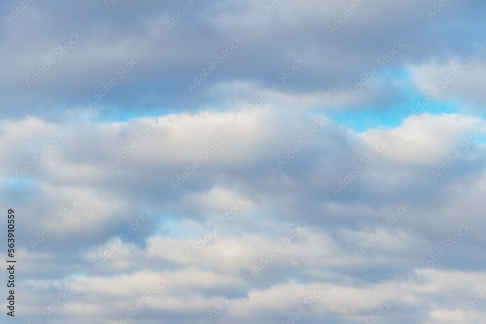 White fluffy clouds densely cover the blue sky