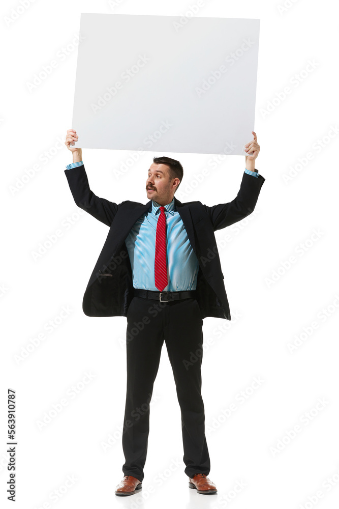 Businessman in a suit holding big empty paper for text over white studio background. Vacancy. Concept of business, career, innovations, ad Businessman in a suit holding big empty paper for text over white studio background. Vacancy. Concept of business, career, innovations, ad