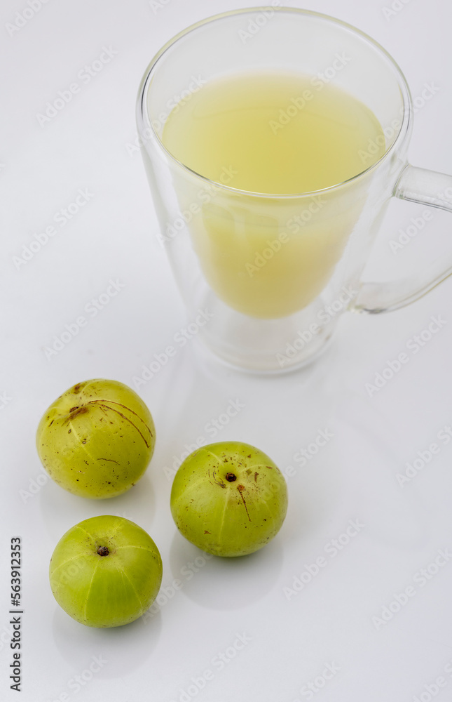 Indian gooseberry or amla fruit and juice having detox properties served in small glasses. Indian gooseberry or amla fruit and juice having detox properties served in small glasses.