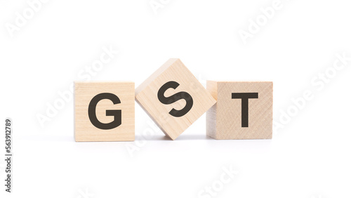 GST - acronym from wooden blocks with letters, Goods and Services Tax concept, top view on white background