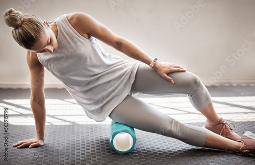 Fitness, physio massage and woman with roller on floor for leg tension and support in yoga workout at gym. Health, pilates and massaging for sports physiotherapy, girl on ground foam rolling muscle.