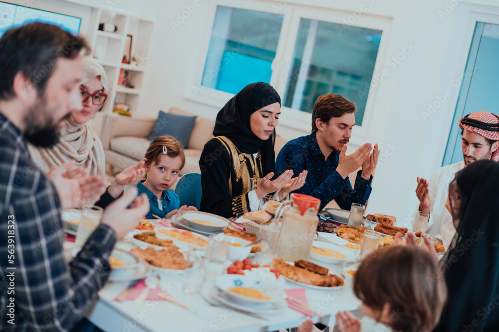 A Muslim family praying together, the Muslim prayer after breaking the fast in the Islamic holy month of Ramadan A Muslim family praying together, the Muslim prayer after breaking the fast in the Islamic holy month of Ramadan