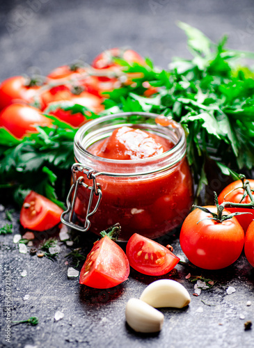 Tomato sauce in a glass jar with parsley and garlic. 