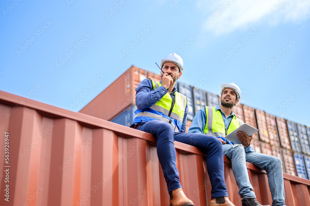 container operators wearing helmets and safety, vests control via walkie-talkie workers in container yards. Cargo Ship Import Export Factory Logistic.