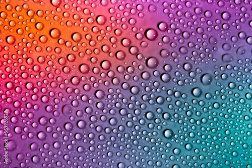 Water drops on glass as a background. Condensation on a cold drink. Multicolored background with drops texture.