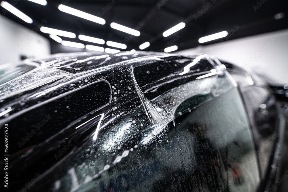 Colorless protective ppf film on the roof of a modern car. The foil protects the car paint from scratches and fading. Car detailing studio