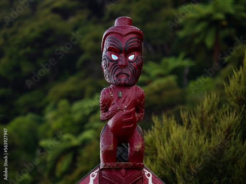 Traditional ancient red wooden Maori sculpture figure in Abel Tasman National Park Tasman South Island New Zealand