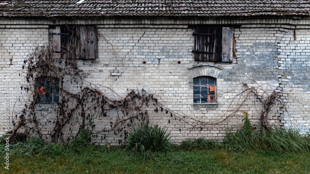 The wall of farm bulding constructed from the gray bricks located in the village