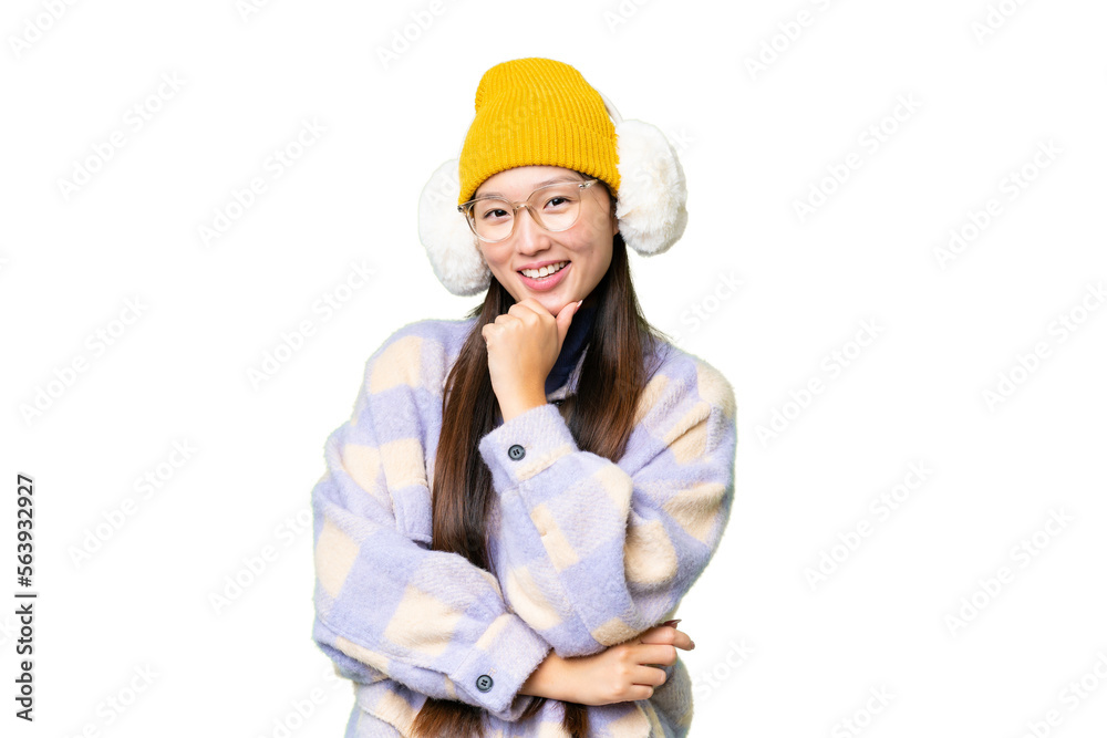 Young Asian woman wearing winter muffs over isolated chroma key background with glasses and smiling