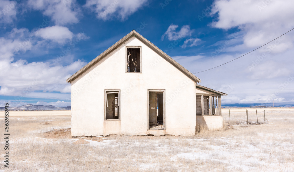 Abandoned homestead on potato farm, San Luis Valley, Colorado, with blue sky, clouds, and snow on a winter day Abandoned homestead on potato farm, San Luis Valley, Colorado, with blue sky, clouds, and snow on a winter day