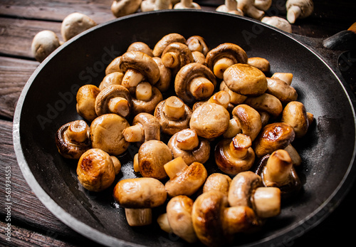 Delicious small fried mushrooms in a frying pan. 