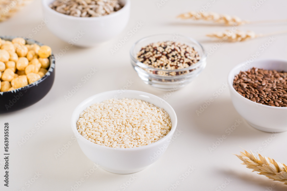 Sesame seeds in a bowl and other seeds in bowls on the table. Healthy food. Sesame seeds in a bowl and other seeds in bowls on the table. Healthy food.