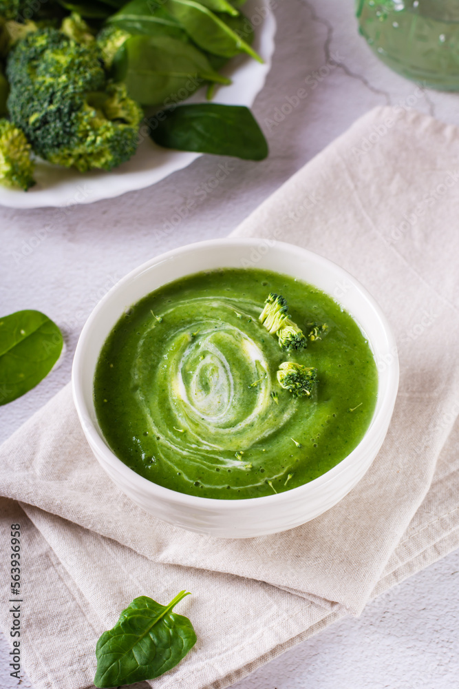 Bowl with broccoli cream soup on the table. Healthy food. Vertical view Bowl with broccoli cream soup on the table. Healthy food. Vertical view