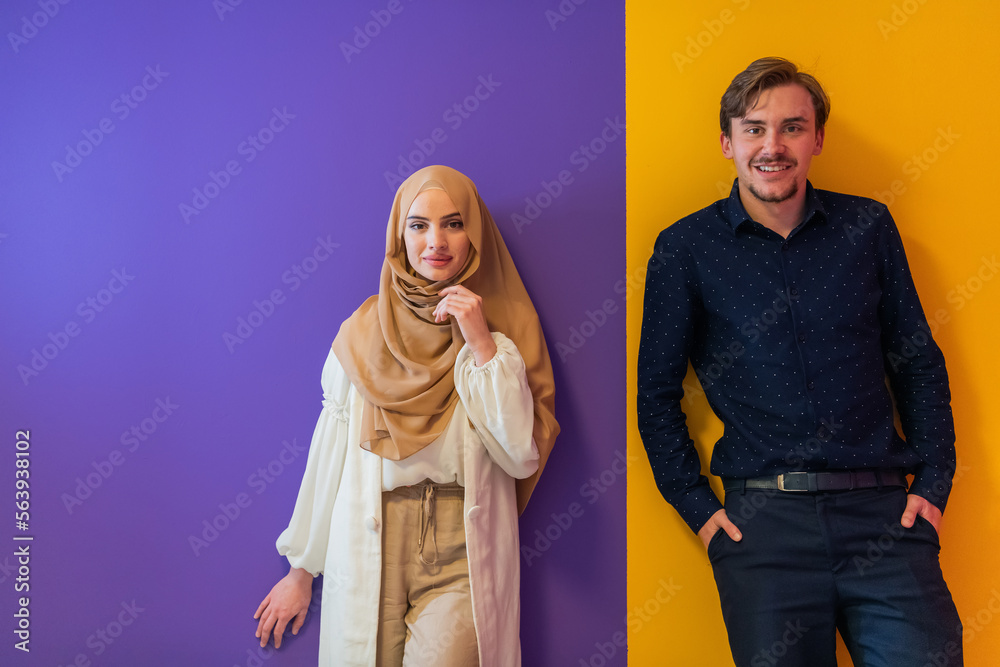 Fototapeta premium Portrait of young muslim couple woman in fashionable dress with hijab isolated on colorful background representing modern islam fashion and ramadan kareem concept