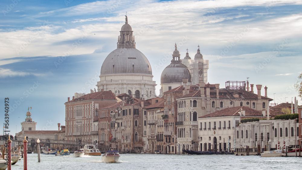 Beautiful panorama of venice at sunrise. Boats sailing along the canals of Venice between private and public buildings under a clear sky.