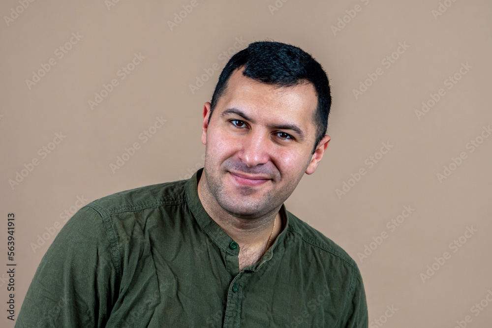 Fototapeta premium Portrait of a happy man 30-35 years old on a light pink background.