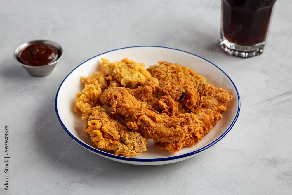 Chicken Popcorn, Wings and Tenders with BBQ Sauce on a plate on a gray background, side view. Chicken Popcorn, Wings and Tenders with BBQ Sauce on a plate on a gray background, side view.