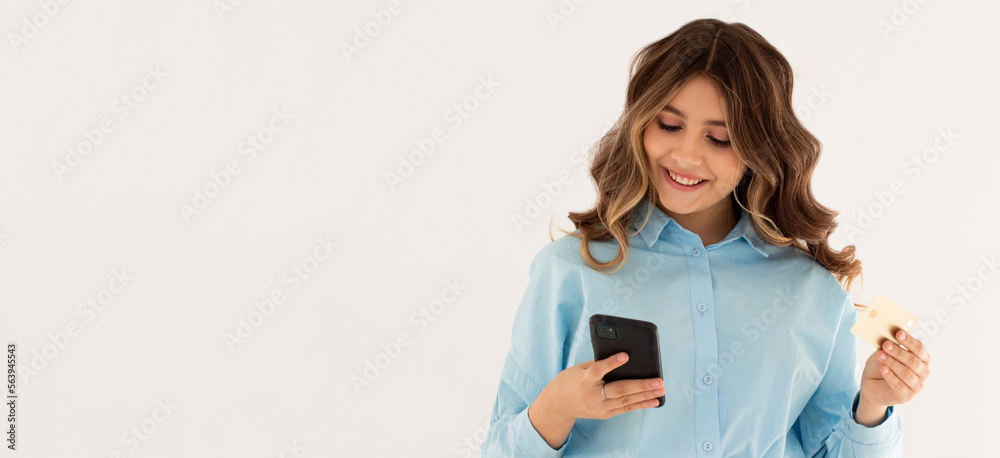 Young brunette woman isolated on white background buying with the mobile with a credit card Young brunette woman isolated on white background buying with the mobile with a credit card