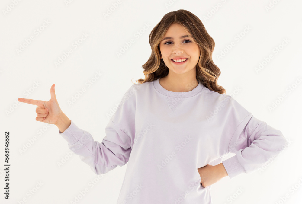 Smiling professional woman in purple sweater, pointing finger left at logo and looking confident at camera, standing on white background. Smiling professional woman in purple sweater, pointing finger left at logo and looking confident at camera, standing on white background.