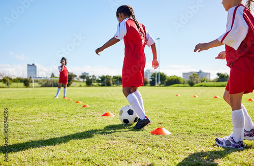 Football, training or sports and a girl team playing with a ball together on a field for practice. Fitness, soccer and grass with kids running or dribbling on a pitch for competition or exercise