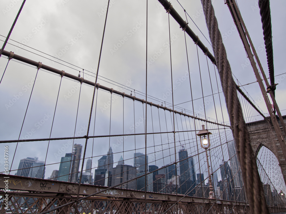 Obraz premium nyc skyline cityscape from the brooklyn bridge on a cloudy day 