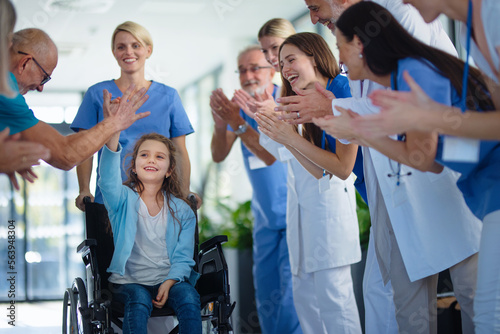 Fototapeta Medical staff clapping to little girl patient who recovered from serious illness