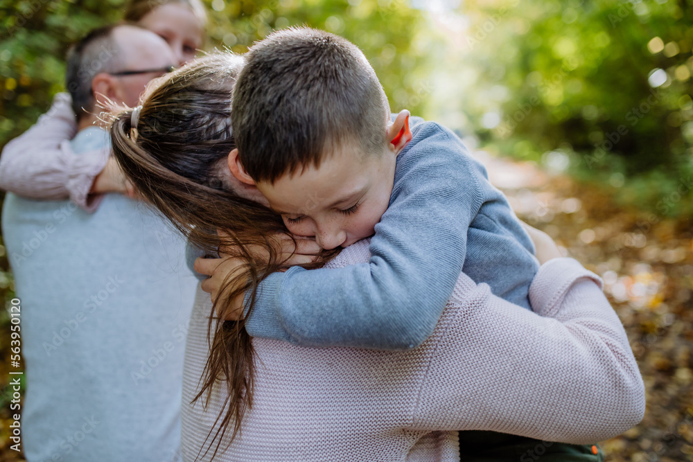Little boy embracing his mother during family walk in forest. Little boy embracing his mother during family walk in forest.