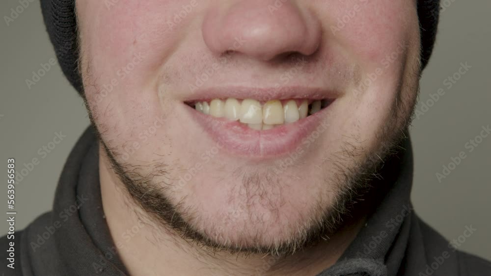 Close-up beauty portrait of a young man with smooth, healthy skin, natural lips, modestly smiling. Natural and healthy smile of a young man. Straight and healthy teeth. Dental concept Close-up beauty portrait of a young man with smooth, healthy skin, natural lips, modestly smiling. Natural and healthy smile of a young man. Straight and healthy teeth. Dental concept