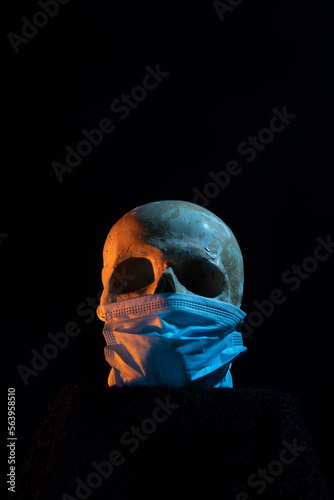A beutiful colorful portrait of an artificial skull with face mask. Health, medicine, safety, death.
