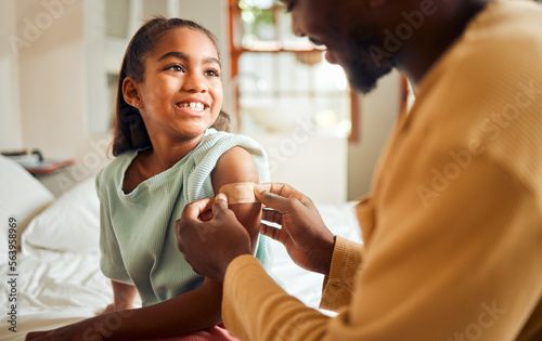 Injury, father and arm bandage for girl after accident in bedroom. First aid, black family and man apply bandaid or plaster on wound of hurt or injured child for wellness, recovery and healthcare. photo