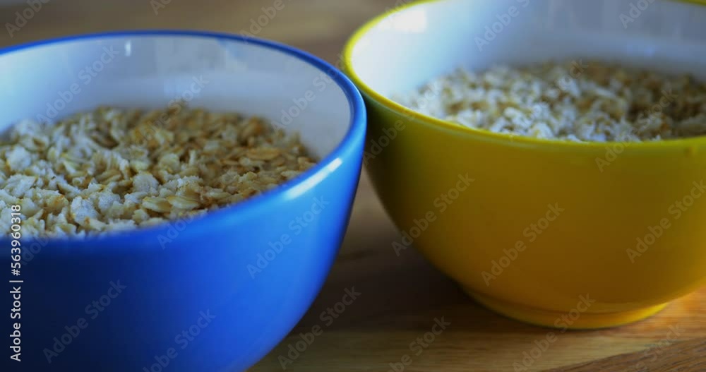 The cups with oatmeal are blue and yellow, the colors of the Ukrainian flag. Breakfast are on a brown wooden table. The concept of a delicious, natural and healthy breakfast. Top view close-up The cups with oatmeal are blue and yellow, the colors of the Ukrainian flag. Breakfast are on a brown wooden table. The concept of a delicious, natural and healthy breakfast. Top view close-up