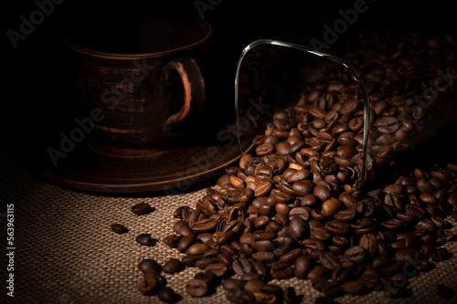 Coffee beans spilled out of the jar onto the table in the kitchen 
