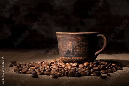 Coffee beans spilled out of the cup on the table in the kitchen 