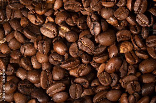 Coffee beans spilled out of the cup on the table in the kitchen 