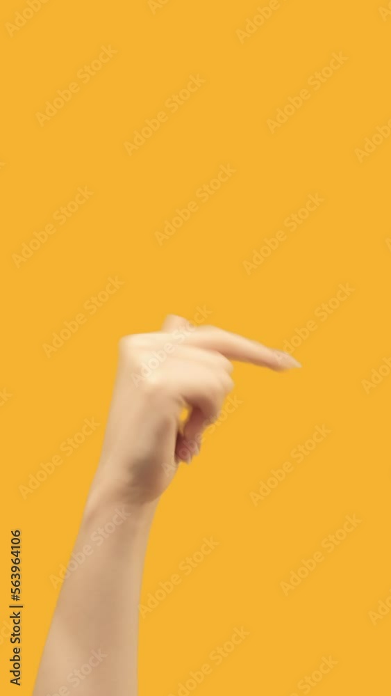 Vertical video. Hand pointing. Next page. Demonstrating gesture. Female finger sign showing right on orange copy space promotional background. Vertical video. Hand pointing. Next page. Demonstrating gesture. Female finger sign showing right on orange copy space promotional background.