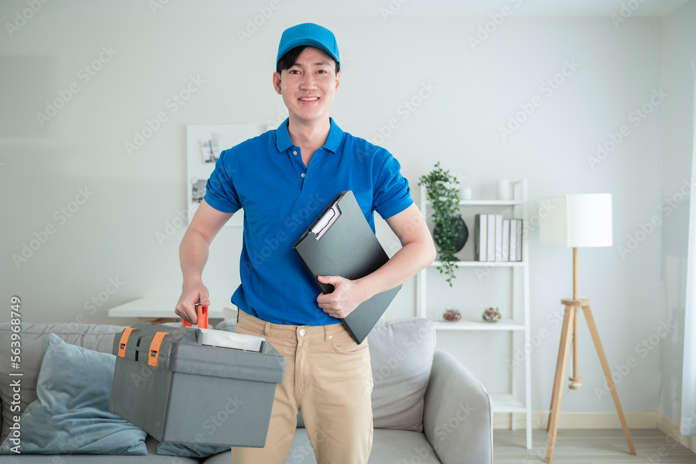 An Asian young Technician service man wearing blue uniform checking electrical appliances in home An Asian young Technician service man wearing blue uniform checking electrical appliances in home