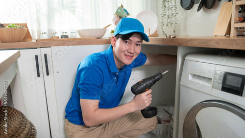 An Asian young Technician service man wearing blue uniform checking electrical appliances in home