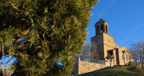 Georgia. Shavnabada Monastery with the Church of St. George on top of Mount Shavnabada on the outskirts of Tbilisi. Walls of the monastery in foreground and the church with bell tower in background photo