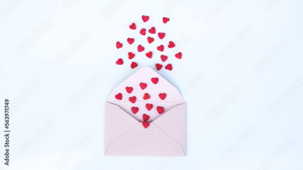 Fototapeta premium Pink paper envelope with Valentines hearts on white background. Flat lay, top view. Romantic love letter for Valentine's day concept.