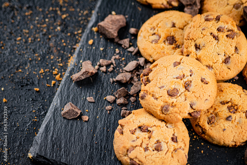 Cookies with pieces of milk chocolate on a stone board. Cookies with pieces of milk chocolate on a stone board.