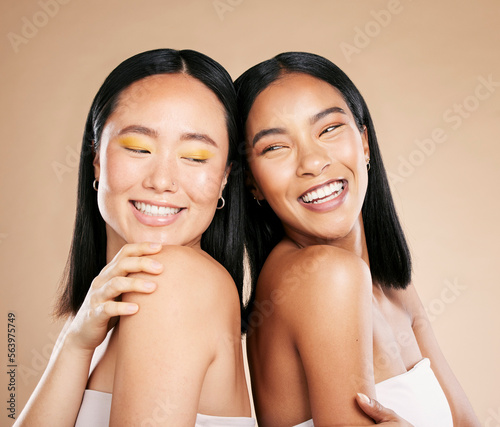 Happy women, diversity and makeup for beauty, skincare and dermatology cosmetics in studio. Asian and black person friends together for skin glow, spa facial and luxury face cosmetic product