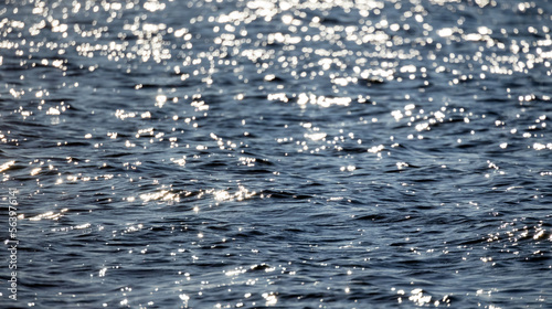 Shiny blue sea water with bright shiny sunbeams, natural photo texture