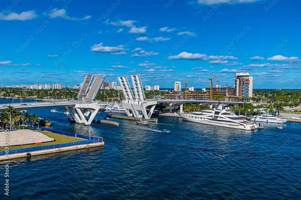 A view of boats sailing through the bridge across the Stranahan River from Port Everglades, Fort Lauderdale on a bright sunny day