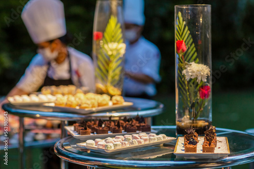 Fototapeta Naklejka Na Ścianę i Meble -  Waiters serving mini canapes pastry desserts during wedding or gala banquet. Beautiful decorated sweet food with fruits