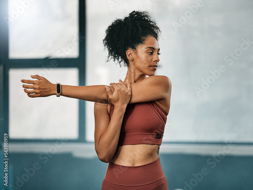 Fitness, black woman or girl in gym stretching arms to warm up body or relax muscles for workout exercise. Wellness, focus or healthy sports athlete ready to start training or exercising in Atlanta photo