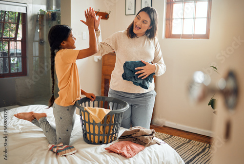 Foto Cleaning, high five and child and mother doing laundry clothes, house work and fold clean fabric